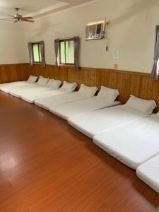 uma fila de camas alinhadas num quarto em Xiaoye Liu Homestay em Guoxing