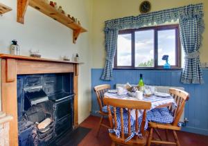 a dining room with a table and a fireplace at Ty Eiddew in Caernarfon