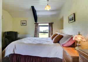a bedroom with a bed and a window at Ty Eiddew in Caernarfon