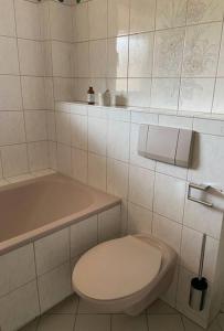 een witte badkamer met een toilet en een bad bij SCHÖNE HELLE FERIENWOHNUNG in Wehr