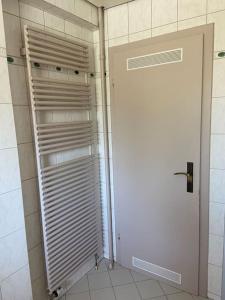 een witte deur in een badkamer met een douche bij SCHÖNE HELLE FERIENWOHNUNG in Wehr