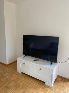 een flatscreen-tv op de top van een witte kast bij SCHÖNE HELLE FERIENWOHNUNG in Wehr