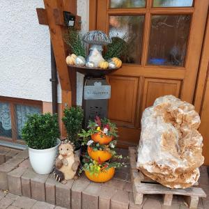 a porch with pumpkins and a cat and a table at Ferienwohnung/ Ferienresidenze Manuela in Obertrubach