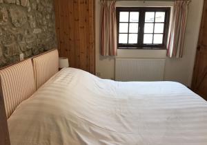 a white bed in a bedroom with a window at Wishing Well in Walton West