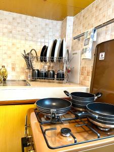 two pans sitting on top of a stove in a kitchen at Cozy 1br milimani in Kisumu