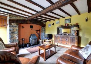a living room with leather furniture and a fireplace at Gors in Llanfair Caereinion