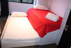 2 camas en una habitación pequeña con sábanas rojas y blancas en Estancia PET FRIENDLY con parqueo y WIFI Gratis, en Guatemala