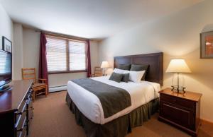 a bedroom with a large bed and a television at Comfortable Zephyr Mountain Lodge condo with the perfect view from the balcony condo in Winter Park