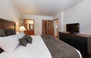 a bedroom with a large bed and a flat screen tv at Comfortable Zephyr Mountain Lodge condo with the perfect view from the balcony condo in Winter Park