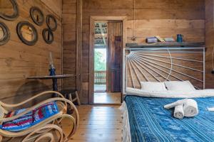 1 dormitorio con 1 cama y pared de madera en Menabde Winery en Ozurgetʼi