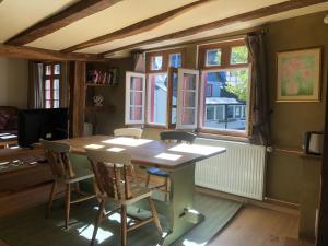 - une salle à manger avec une table, des chaises et des fenêtres dans l'établissement An der Rur - 4 Apartments mitten in Monschau, à Monschau