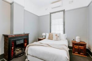 马奇Federal Hotel Mudgee的带床和壁炉的卧室