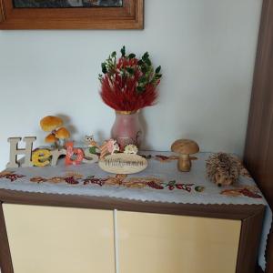 a table with a vase of flowers and a cake on it at Ferienwohnung/ Ferienresidenze Manuela in Obertrubach