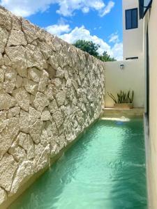 Villa Maia, Lovely 1 bedroom apartment with pool في ميريدا: تجمع مياه بجانب جدار حجري