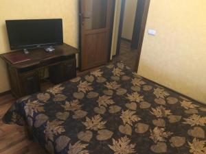 a hotel room with a bed and a desk and a television at Pan Otaman in Pisarevka