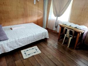 a bedroom with a bed and a table and a window at Batad Countryside in Banaue