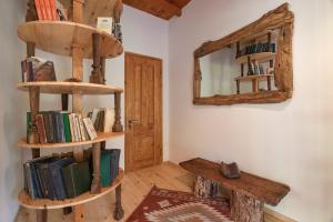 una stanza con scaffali in legno, libri e specchio di Menabde Winery a Ozurgetʼi