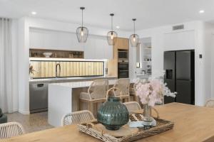 a kitchen with a table with a vase on it at Beach Life Luxury Escape Kingscliff in Kingscliff