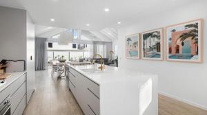 a kitchen with white cabinets and a white counter top at Gone Coastal in Kingscliff