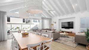 a dining room and living room with a table and chairs at Gone Coastal in Kingscliff