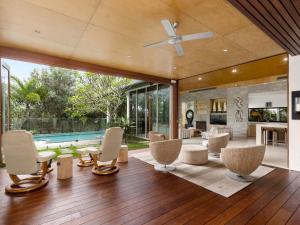 an open living room with chairs and a ceiling fan at Beachfront On Northpoint in Kingscliff
