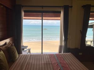 a bedroom with a bed and a view of the beach at Lanta Paragon in Ko Lanta