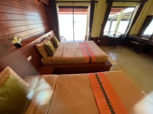 a bedroom with two beds and a couch in it at Lanta Paragon in Ko Lanta