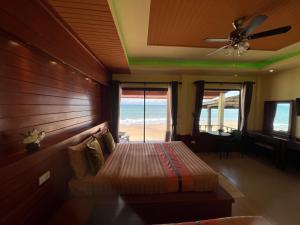 a bedroom with a bed with a view of the beach at Lanta Paragon in Ko Lanta