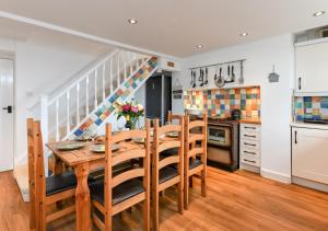 a kitchen and dining room with a wooden table and chairs at Tyddyn Talgoch Isaf in Abersoch