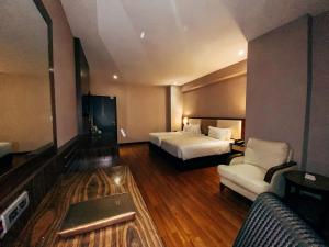 a hotel room with two beds and a couch at Vouk Hotel Suites, Penang in George Town