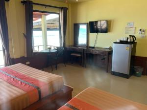 Habitación con cama, escritorio y TV. en Lanta Paragon en Ko Lanta