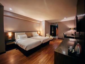 a hotel room with a large bed and a desk at Vouk Hotel Suites, Penang in George Town