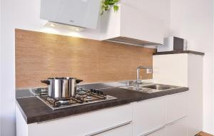 a kitchen with a sink and a pot on a stove at 1 Bedroom Nice Apartment In Pozzallo in Pozzallo
