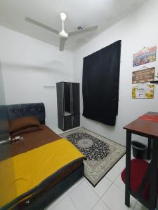 1 dormitorio con cama, escritorio y mesa en LH Alisha Homestay Wangsa Mewangi Gua Musang en Gua Musang