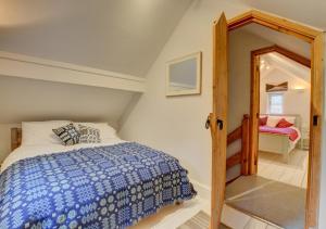 a bedroom with a bed with a blue comforter at Ty Rowan in Trefriw