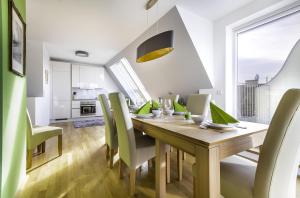 ein Esszimmer mit einem Holztisch und grünen Stühlen in der Unterkunft Abieshomes Serviced Apartments - Messe Prater in Wien