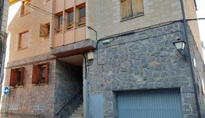 um edifício de pedra com uma porta e uma garagem em La Marmota Suite apartamento rústico en Panticosa em Panticosa