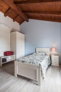 Savorgnano的住宿－明尼辛農家樂，卧室设有白色的床和木制天花板。