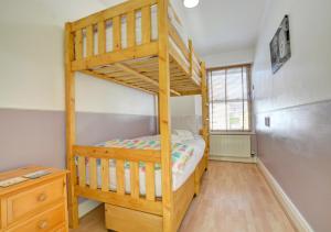 テンビーにあるHoney Cottageのデスクが備わる客室の木製二段ベッド1台分です。