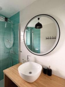 bagno con lavandino e specchio di Chambres d'hôtes Saint-Hélen a Saint-Hélen