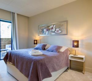 RognesにあるSweet lodges chambre d hôtes Aix en Provenceのベッドルーム1室(紫色のベッドカバー付)