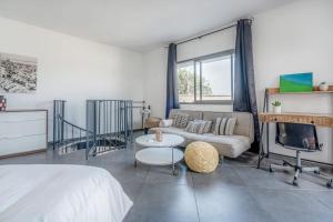 a bedroom with a bed and a couch and a fireplace at Duplex In Flea Market by Holiday-rentals in Tel Aviv