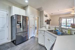a kitchen with a stainless steel refrigerator and a sink at Cozy Wilmington Bungalow about 6 Mi to Beaches! in Wilmington