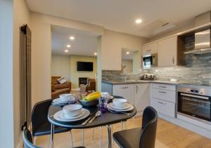a kitchen with a table and chairs in a room at The Retreat in Saundersfoot