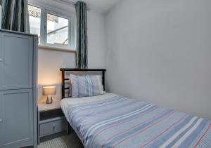a small bedroom with a bed and a window at The Retreat in Saundersfoot