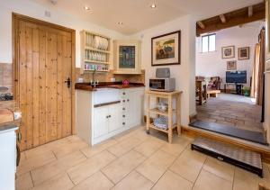 eine große Küche mit einer Theke und einer Tür in der Unterkunft The Barn in Llannor