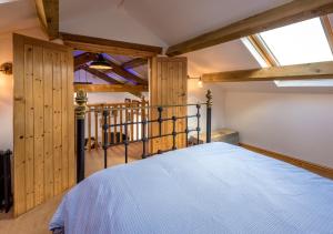 ein Schlafzimmer mit einem Bett in einem Zimmer mit Holzwänden in der Unterkunft The Barn in Llannor