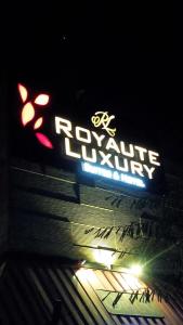 Royaute Luxury Suites and Hotel Gulberg Lahore في لاهور: علامة نيون على جانب المبنى