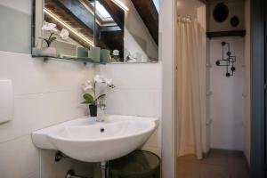 a bathroom with a white sink and a mirror at Iseo Vicolo Portelle - indoor private parking & bike storage in Iseo +37 photos