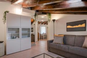 a living room with a couch and a table at Iseo Vicolo Portelle - indoor private parking & bike storage in Iseo